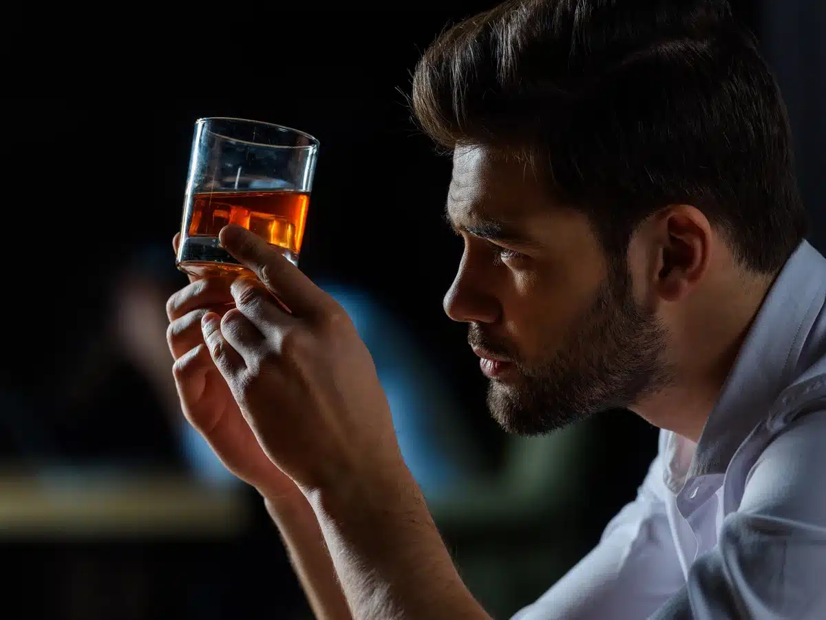 Understanding Alcohol Withdrawal - man looking at a glass of whiskey